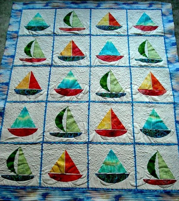 a quilted wall hanging with sailboats on it's sides and the top half in different colors