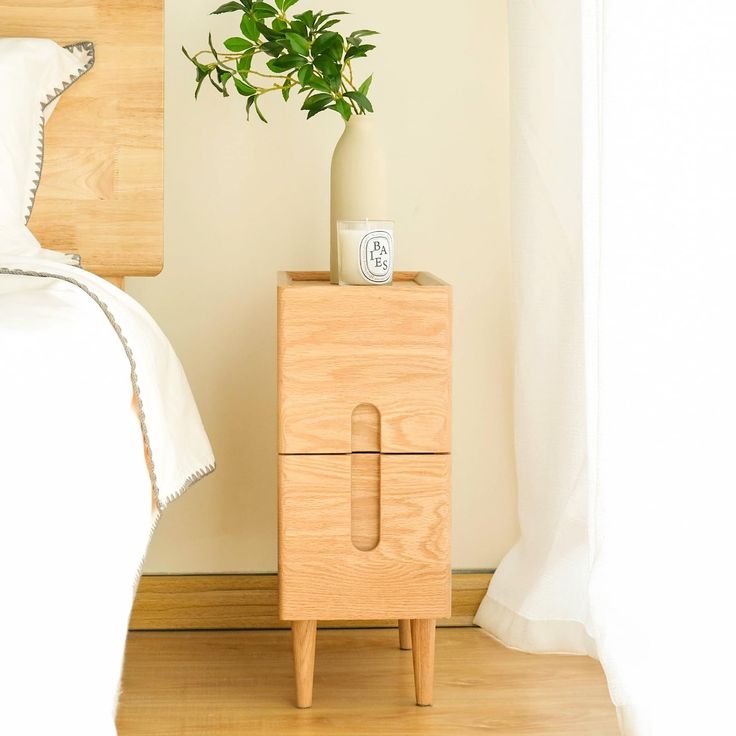 a wooden nightstand with a plant on top