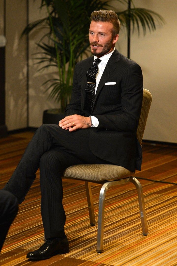 a man in a tuxedo sitting on a chair