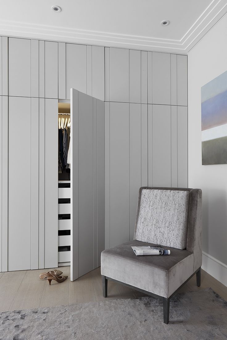 a chair sitting on top of a rug next to a wall covered in closet doors