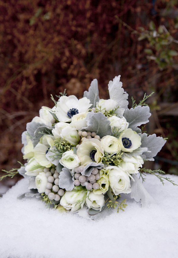 a bridal bouquet sitting on top of snow covered ground