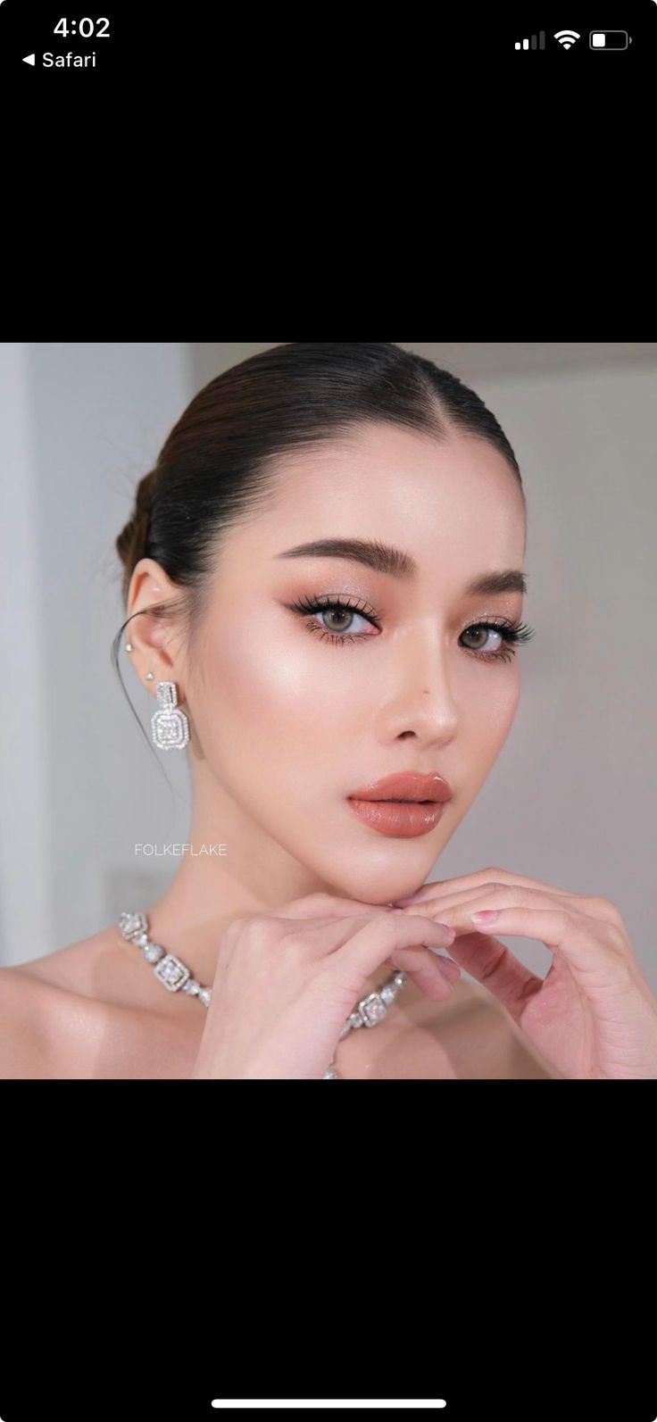 an image of a woman with makeup and jewelry on her face, looking at the camera