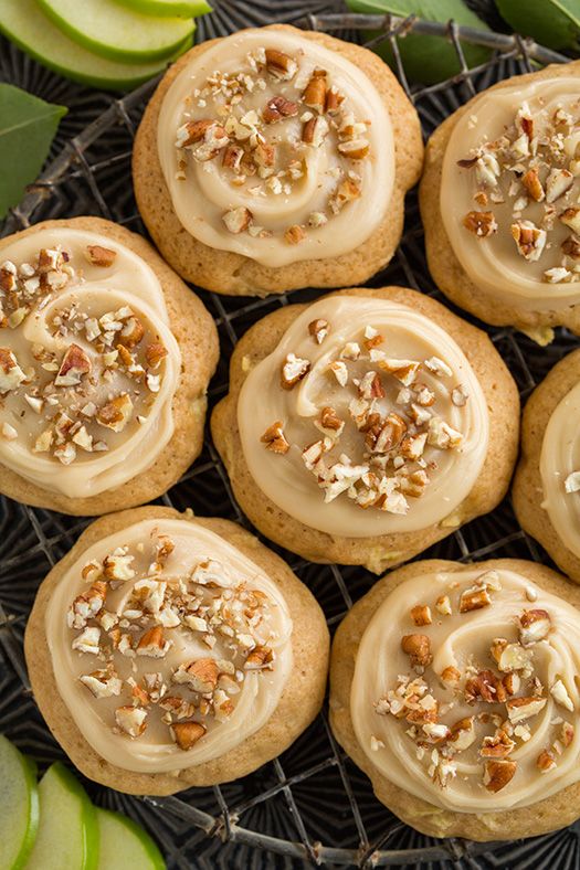 several cookies with frosting and nuts on a cooling rack