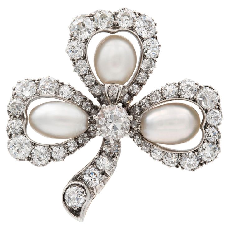 A Victorian pearl and diamond cluster clover leaf brooch, each petal set with a pear natural shaped pearl to the centre of an old-cut diamond set open cluster surround, with diamond-set stalk, the diamonds estimated to weigh a total of 3 carats all set in silver to a yellow gold mount with brooch fitting, circa 1880, measuring approximately 3.3 x 3.3cm, gross weight 11.2 grams. Unmarkedtested as 18ct gold and Silver. A Victorian pearl and diamondclover leaf brooch in Good condition, with histori Diamond Brooches, Leaf Brooch, Antique Brooches, Diamond Brooch, Pearl Brooch, Women Diamond, Pearl Diamond, Diamond Set, Lovely Jewellery