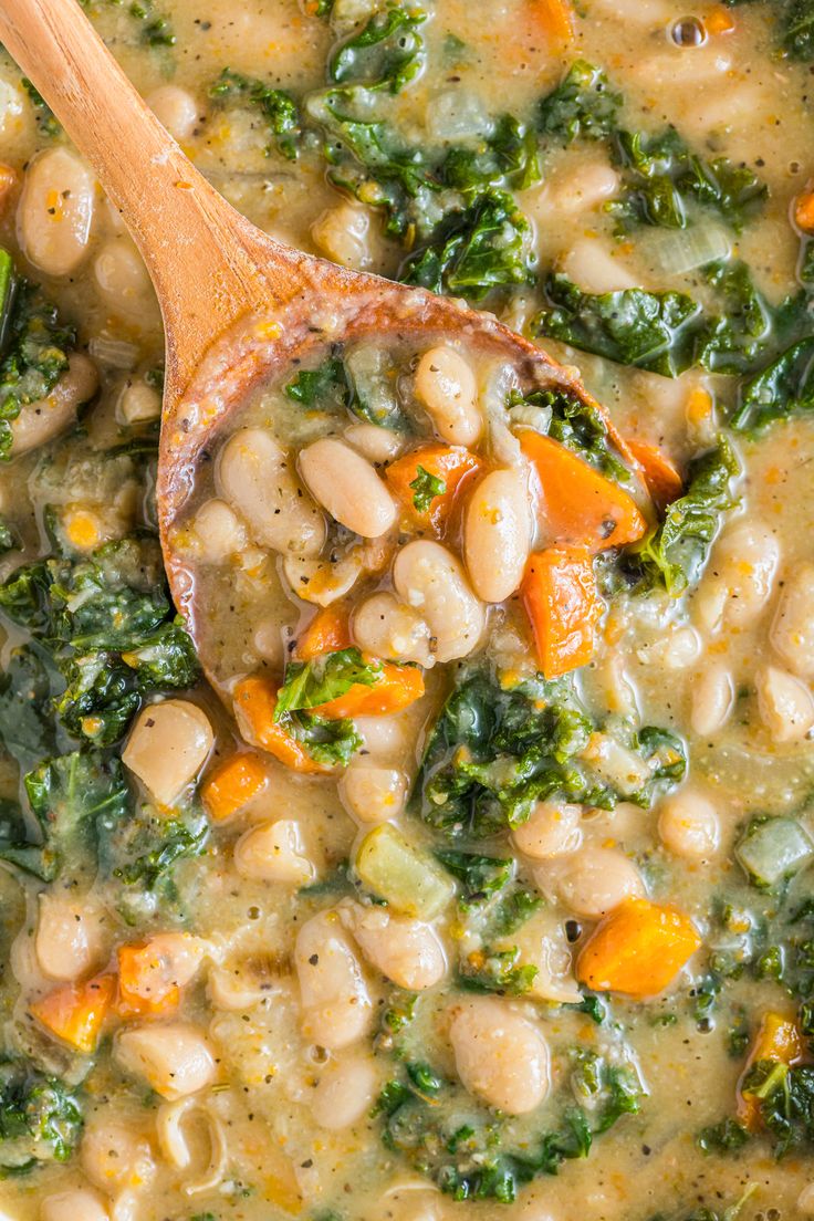 a wooden spoon filled with white beans and broccoli