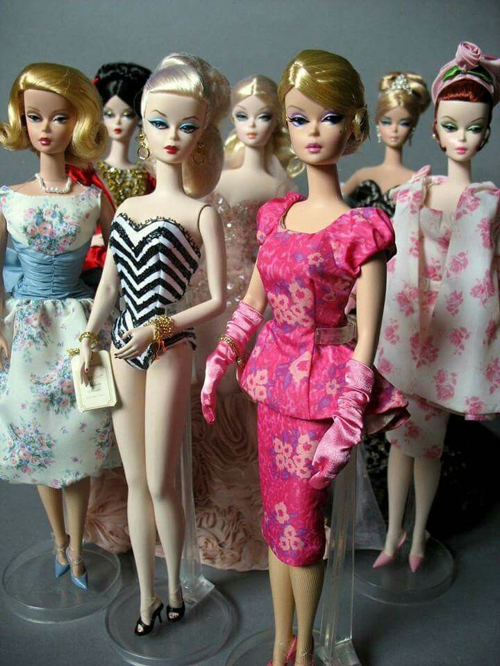 a group of barbie dolls standing next to each other