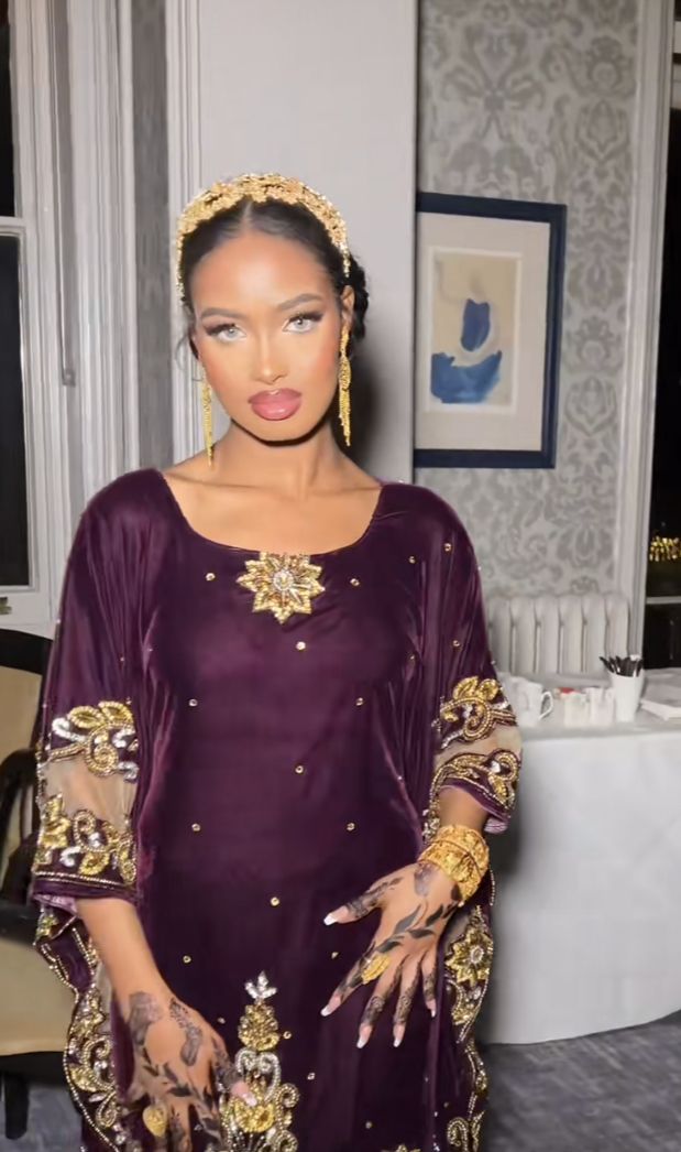 a woman in a purple dress standing next to a table