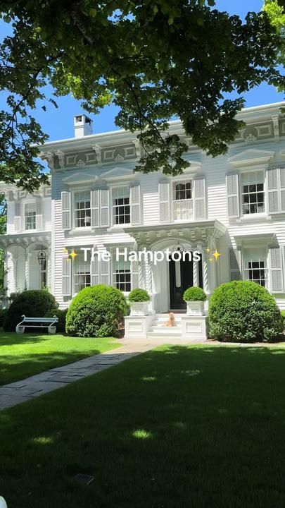 a large white house sitting on top of a lush green field