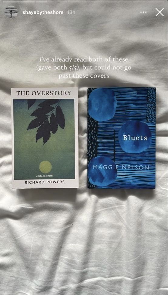 two books sitting on top of a bed next to each other in front of a white sheet