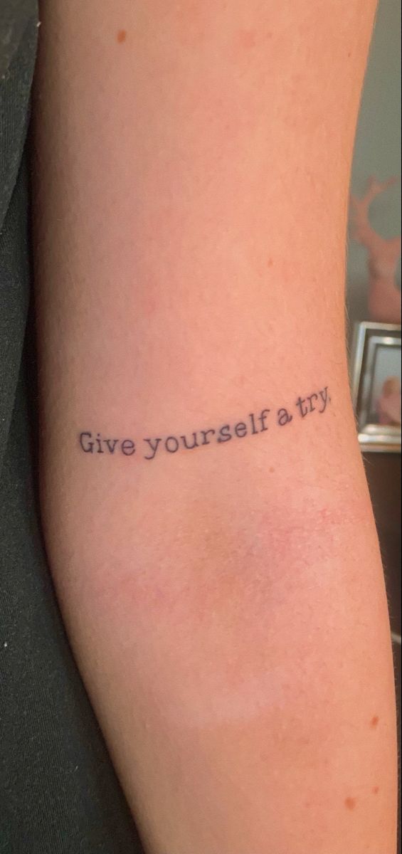 a person with a tattoo on their arm that says give yourself a try in black ink