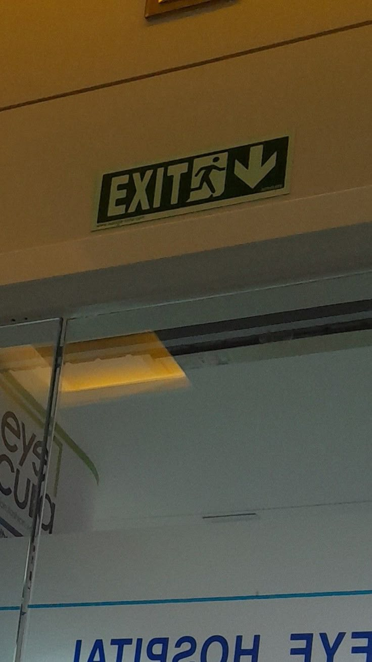 an exit sign is posted on the side of a hospital room door that says eye hospital