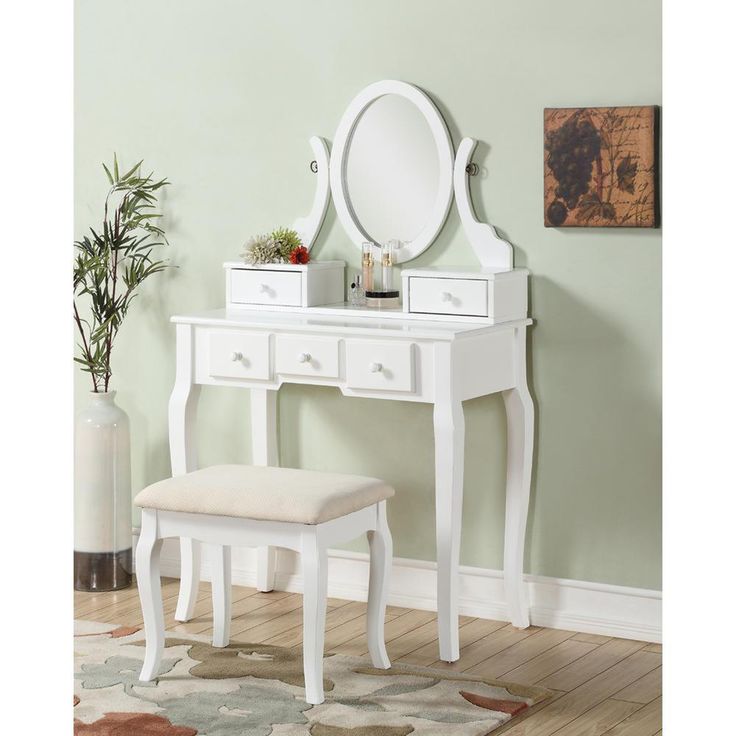 a white dressing table with a mirror and stool in front of it on top of a hard wood floor