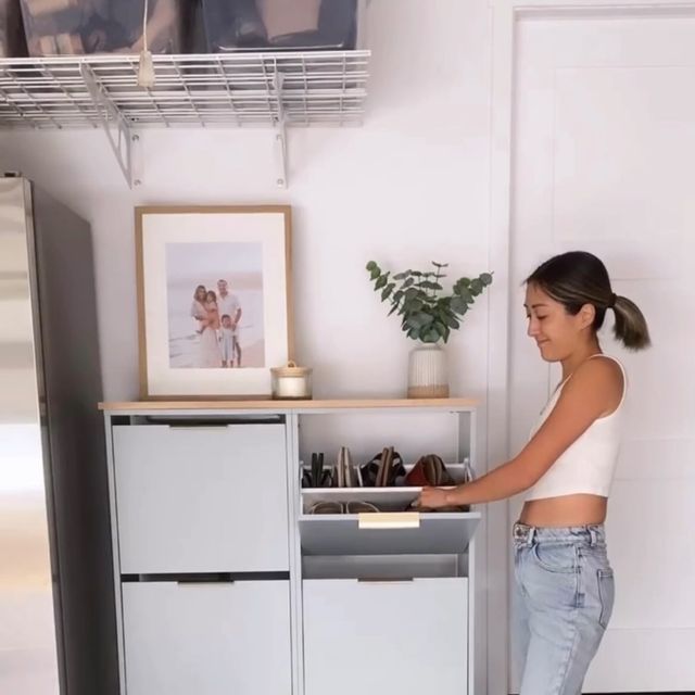 a woman standing in front of a white cabinet