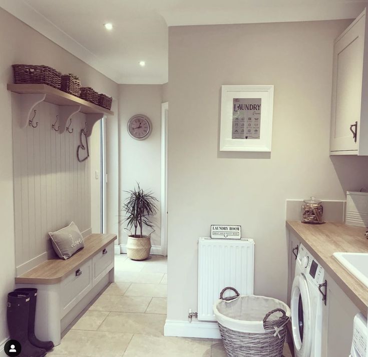 a washer and dryer in a small room with tile flooring on the walls