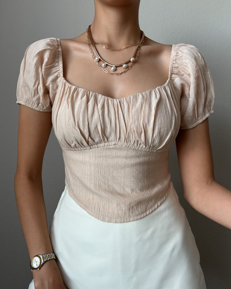 Upgrade your wardrobe with the Belen Tie Back Crop Top! This beige crop top features a ruched bust and tie-back, adding a touch of style and structure to any outfit. The perfect versatile piece to take you from day to night with ease. More details: - Fits true to size for most - Does stretch - Tie back - 100% Polyester - Color may vary due to the lighting - Model is wearing a size small Model Details Height 5'7 | Chest 34" Waist 27" Hips 36.5" | Weight 118lbs | Wears a US size small in tops and Beige Crop Top, Tie Back Crop Top, Beige Crop Tops, Day To Night, To Night, Tie Backs, Tie Back, Wardrobe Staples, Dresses For Sale