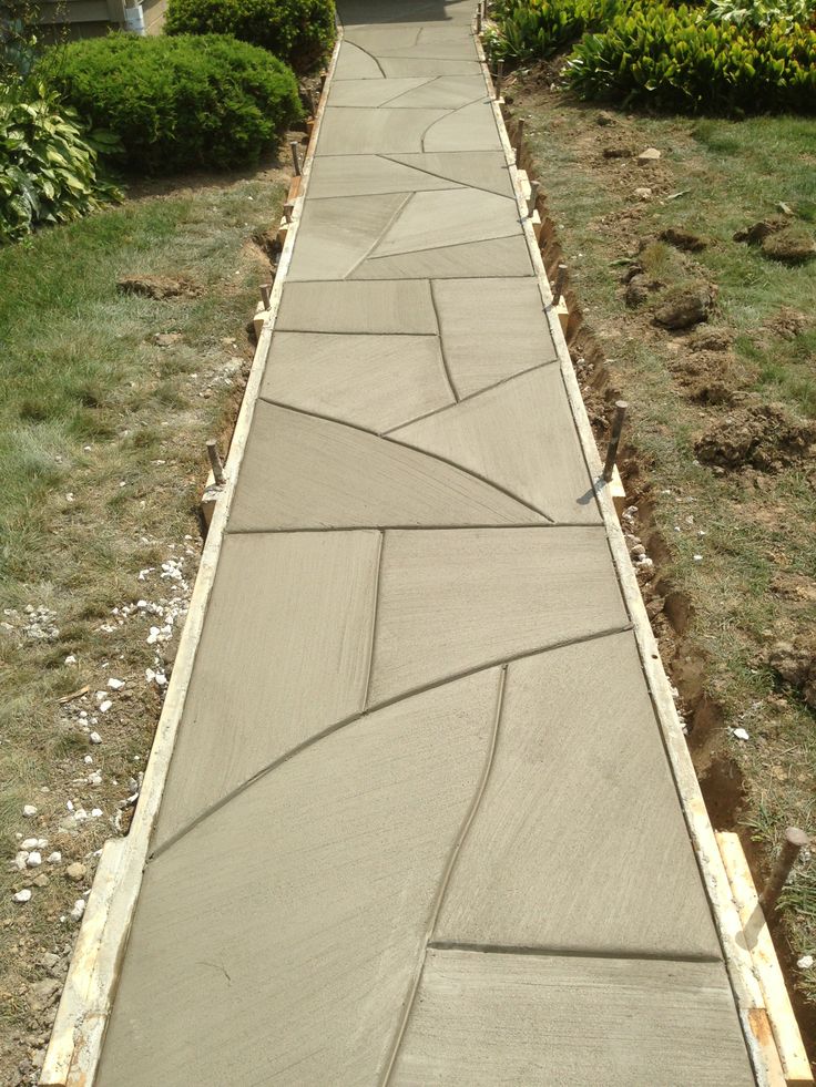 a walkway made out of concrete in front of a house