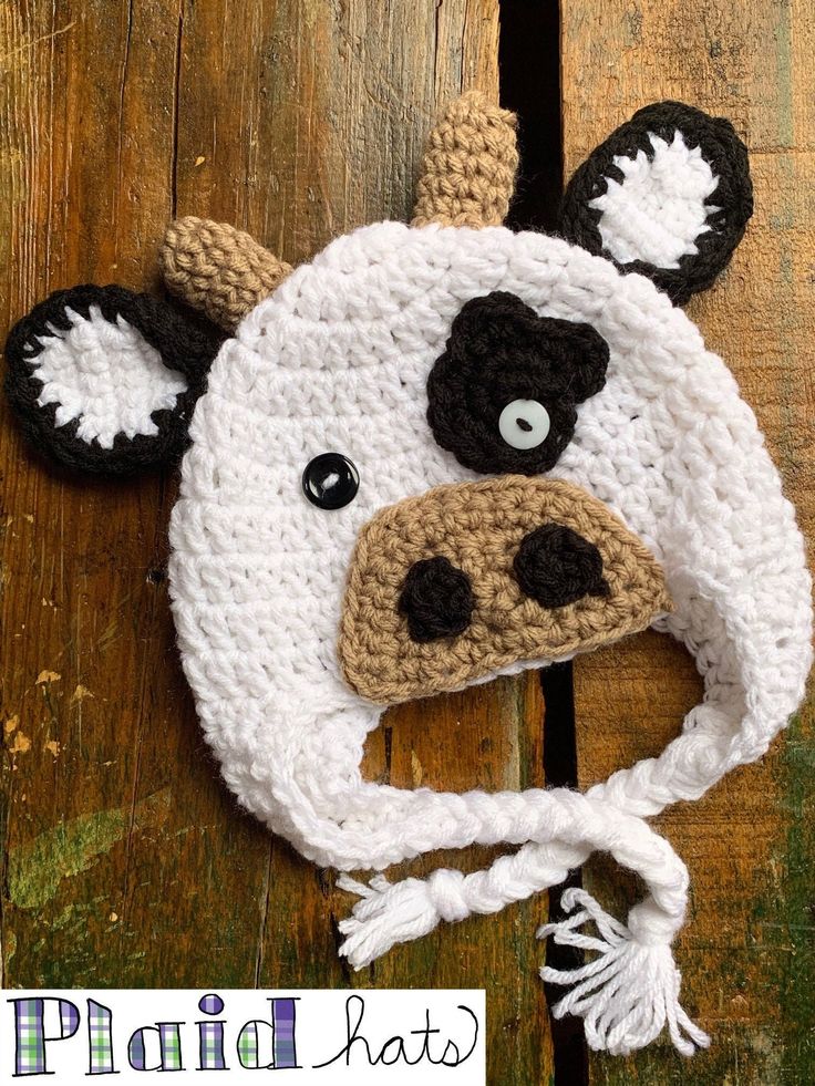 a crocheted cow hat on top of a wooden table