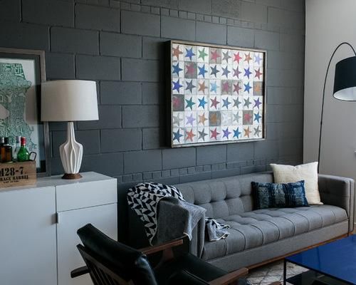 a living room filled with furniture and a painting hanging on the wall over a blue coffee table