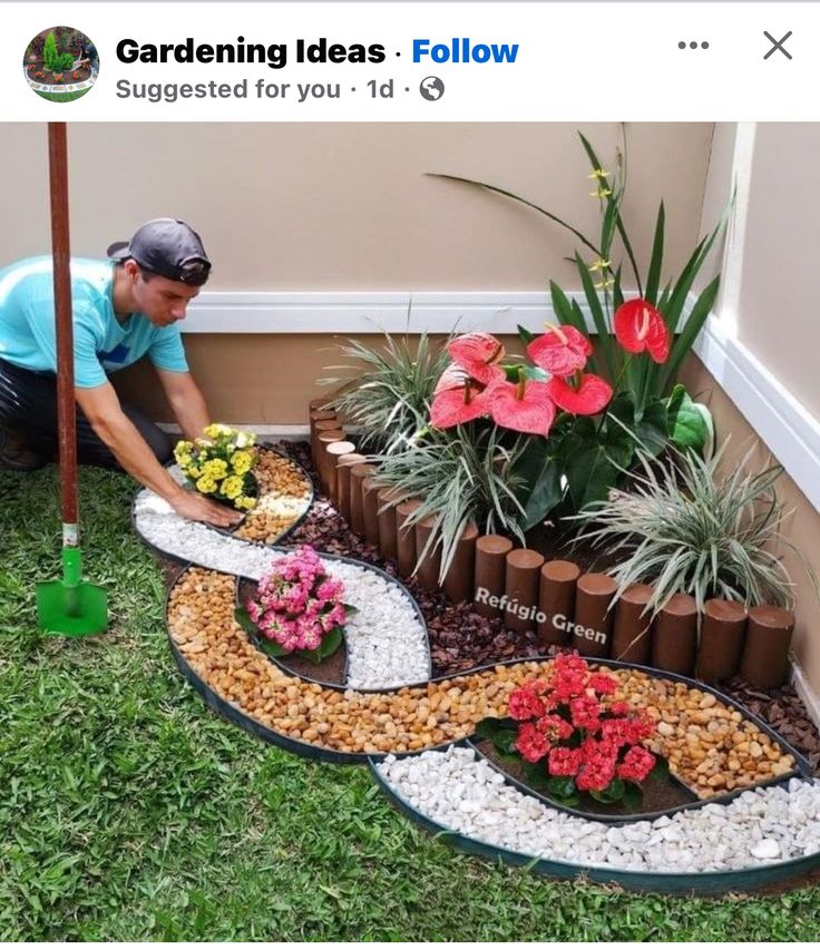 a man kneeling down next to a flower garden on top of a green grass covered ground