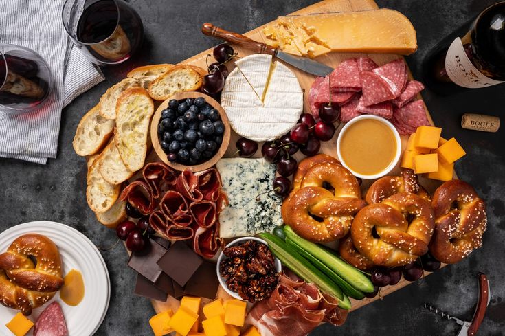 an assortment of cheeses, meats, and breads on a platter