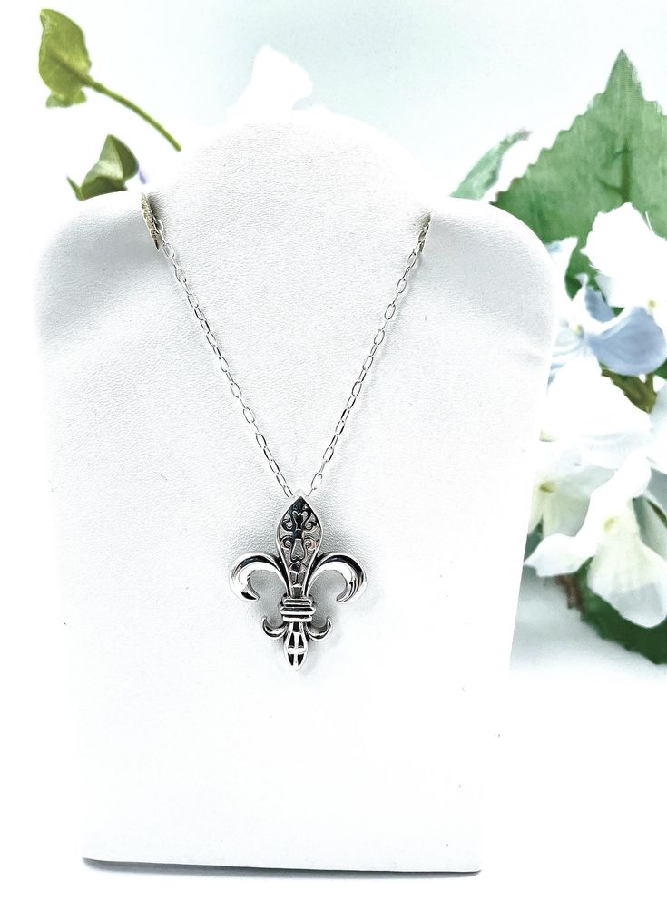 ntroducing our exquisite 925 sterling silver Fleur de Lis pendant necklace, a timeless symbol of elegance and sophistication. This pendant is expertly crafted and stamped with the 925 hallmark, ensuring its authenticity and superior quality. The pendant measures approximately 0.93 inches in width and 1.22 inches in length, making it a perfect statement piece without being overly large. For your convenience, this pendant is available with an optional 18-inch sterling silver cable link chain, allowing you to customize your look to suit your style. This necklace not only enhances your jewelry collection but also makes a thoughtful gift for someone special. Embrace the classic beauty of the Fleur de Lis with this stunning sterling silver pendant necklace. Satisfaction Guaranteed! Silver 925 Stamped Necklace For Mother's Day, Classic Sterling Silver Pendant Charm Necklace, Classic Sterling Silver Jewelry With Hallmark, Classic Sterling Silver Necklace For Memorial, Classic Sterling Silver Necklace Stamped 925, Classic Sterling Silver Charm Necklace For Anniversary, Classic Silver Necklace Gift, Classic Sterling Silver Necklace For Mother's Day, Classic Sterling Silver Charm Necklace For Gift