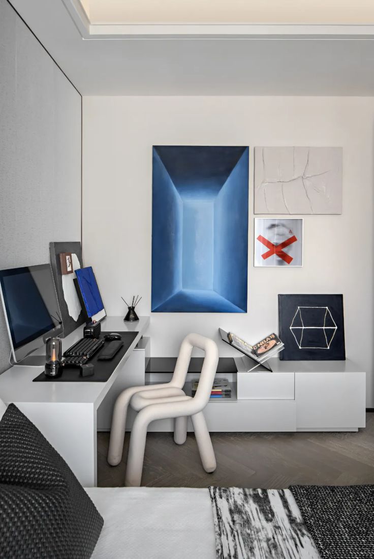 a modern living room with white furniture and art on the wall, including two computer desks