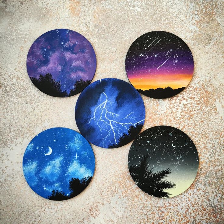 four coasters with different pictures of the night sky and stars on them, all painted to look like lightning