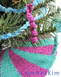 a crocheted christmas ornament hanging from a pine tree