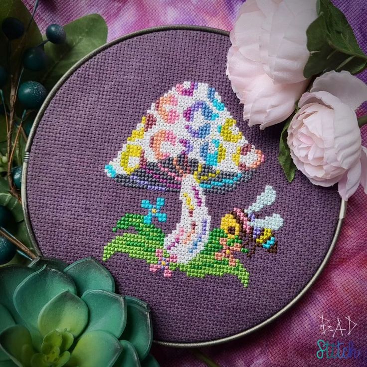 a cross - stitched picture of a mushroom with flowers