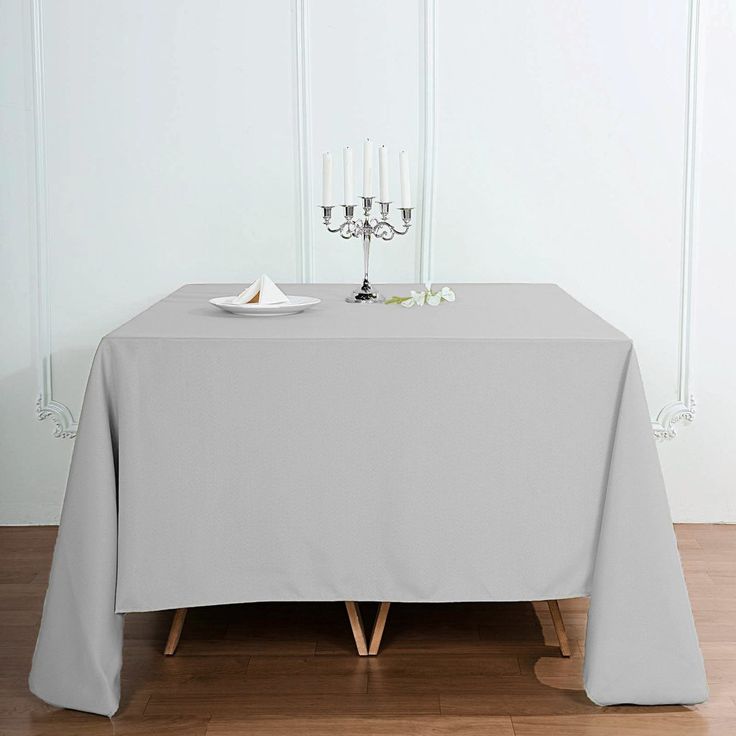 the table is set with two candles and a plate on it, ready for dinner