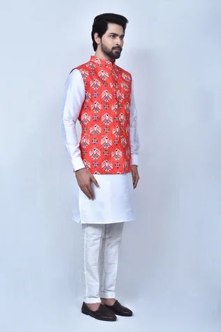 Orange bundi in cotton silk base with patola prints. Comes with off white kurta and pant.
Components: 3
Pattern: Printed
Type Of Work: Patola Patterns
Neckline: Mandarin Collar
Sleeve Type: Bundi: Sleeveless, Kurta: Cuff Sleeves
Fabric: Kurta and Pant: Art Silk, Bundi: Cotton Silk
Color: Orange, Off White
Other Details: 
Front carved button bundi
Welt pocketed bundi
Elasticated pant waistband
Occasion: Wedding - Aza Fashions Cotton Nehru Jacket Straight Kurta For Festivals, Cotton Bandhgala With Printed Motifs For Festive Occasions, Cotton Bandhgala For Navratri Puja, Festive Cotton Nehru Jacket Straight Kurta, Cotton Nehru Jacket For Festivals, Cotton Nehru Jacket For Puja And Eid, Cotton Nehru Jacket With Cutdana In Straight Kurta Style, Traditional Cotton Silk Nehru Jacket With Cutdana, Cotton Nehru Jacket For Eid Puja