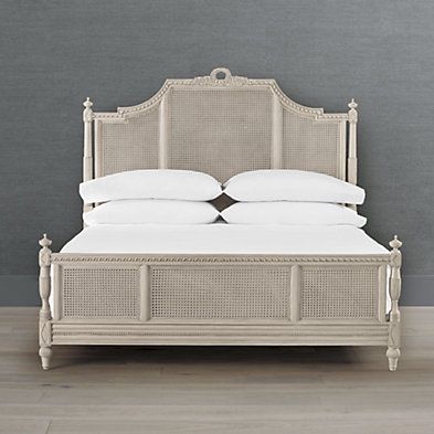 the bed is made with wicker and white linens on it's headboard