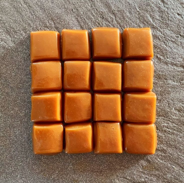 several squares of orange colored soap sitting on top of a gray carpeted floor next to each other