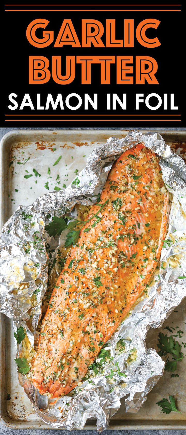 garlic butter salmon in foil on a baking sheet with the title, garlic butter salmon in foil