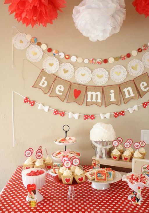 a table topped with cupcakes and cake next to a banner that says vintage valentine party