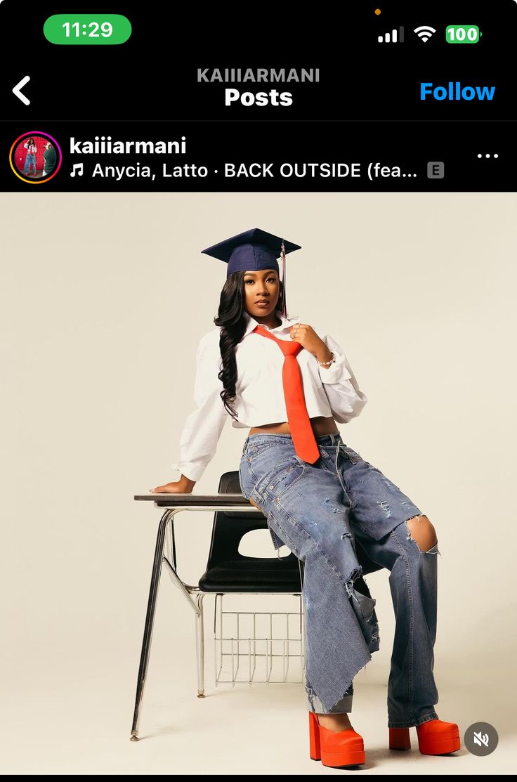 a woman sitting on top of a chair wearing a graduation cap and orange neck tie