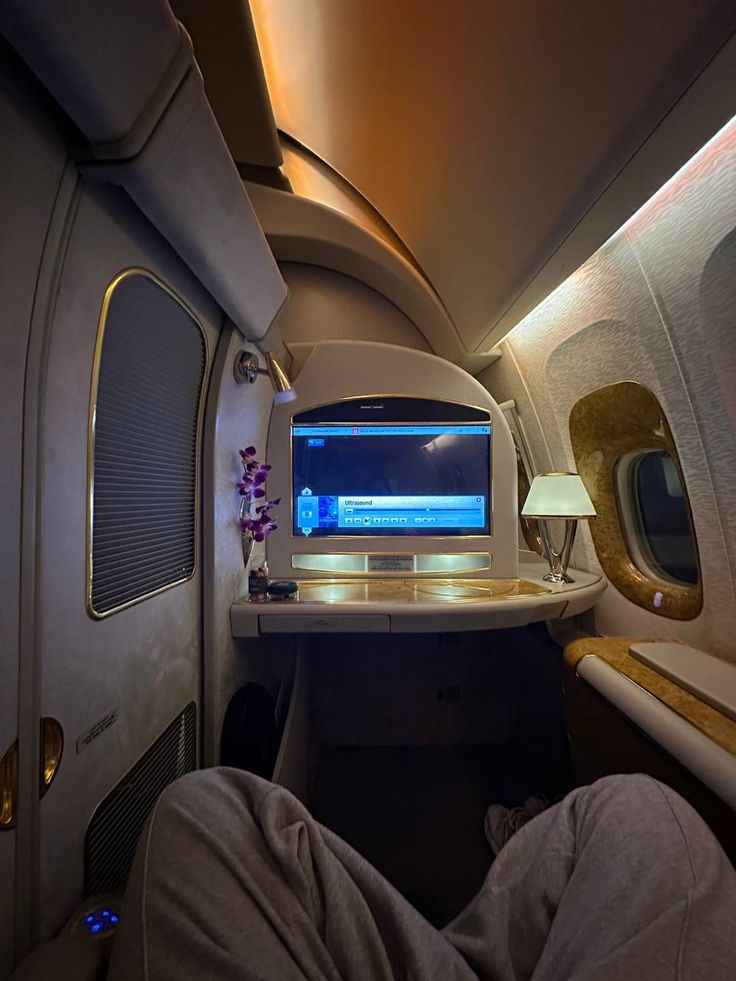 the inside of an airplane with a desk and computer monitor on it's side