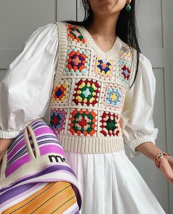 a woman in a white dress holding a colorful purse