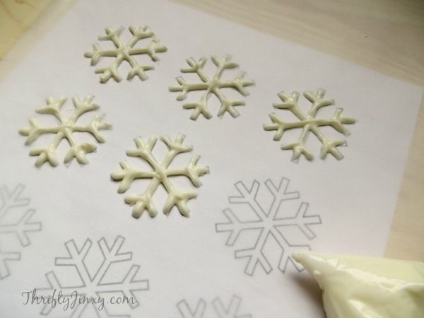 snowflakes are cut out and placed on paper