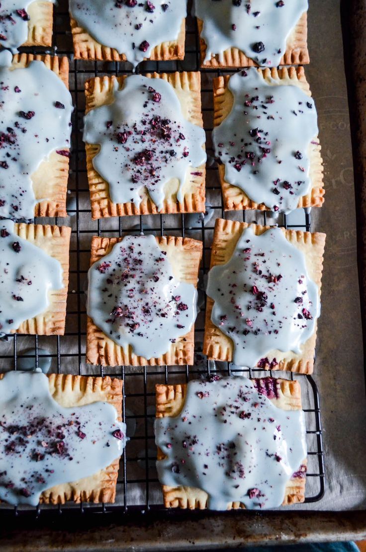 some cookies with white icing and cranberries on a cooling rack