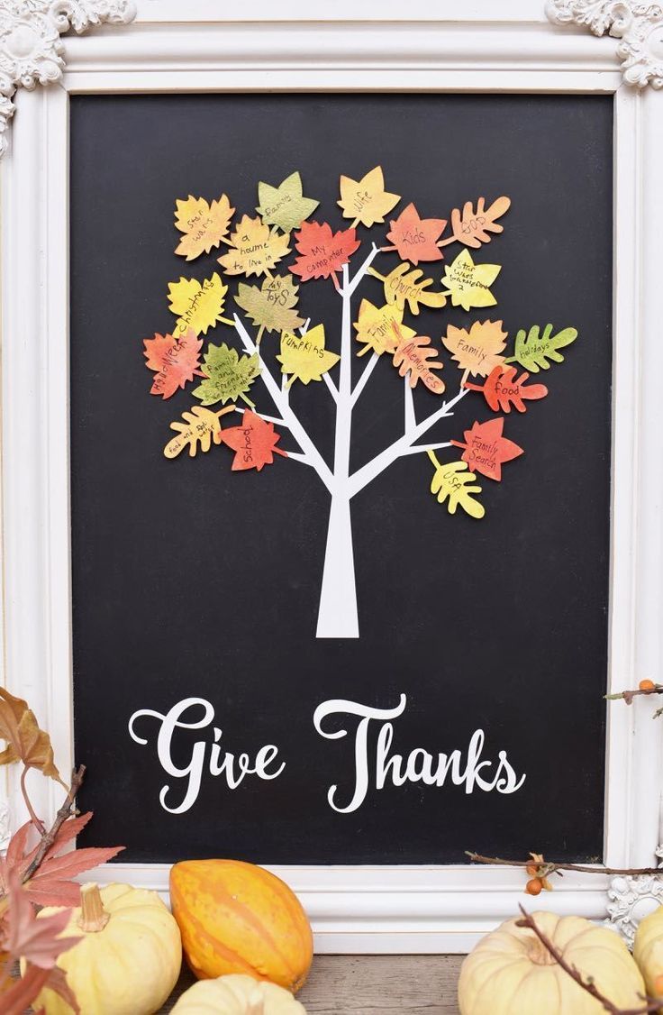 a chalkboard with the words give thanks written on it next to fall leaves and pumpkins