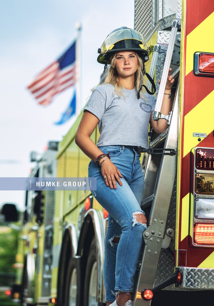 a woman wearing a firefighter's helmet leaning on the side of a fire truck