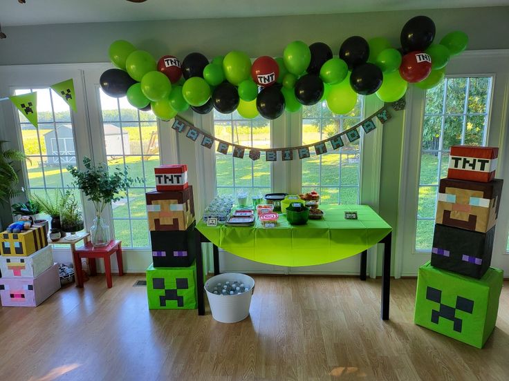 a room decorated for a minecraft birthday party with balloons and decorations on the ceiling