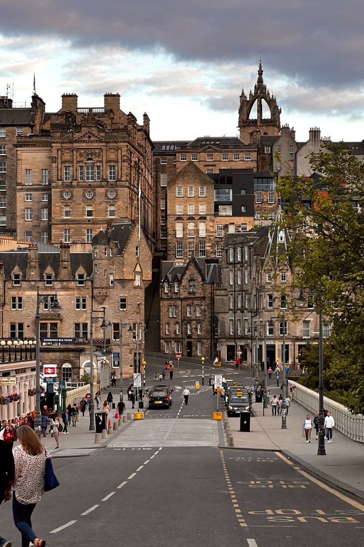 people are walking down the street in front of buildings