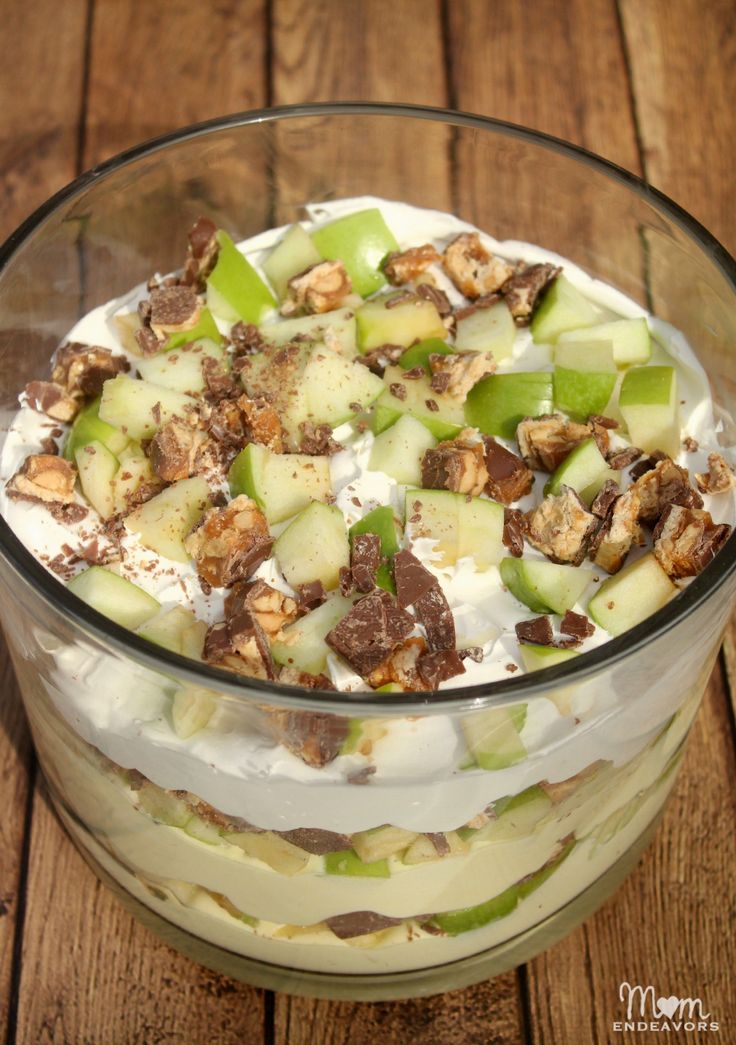 an apple dessert in a glass bowl on a wooden table