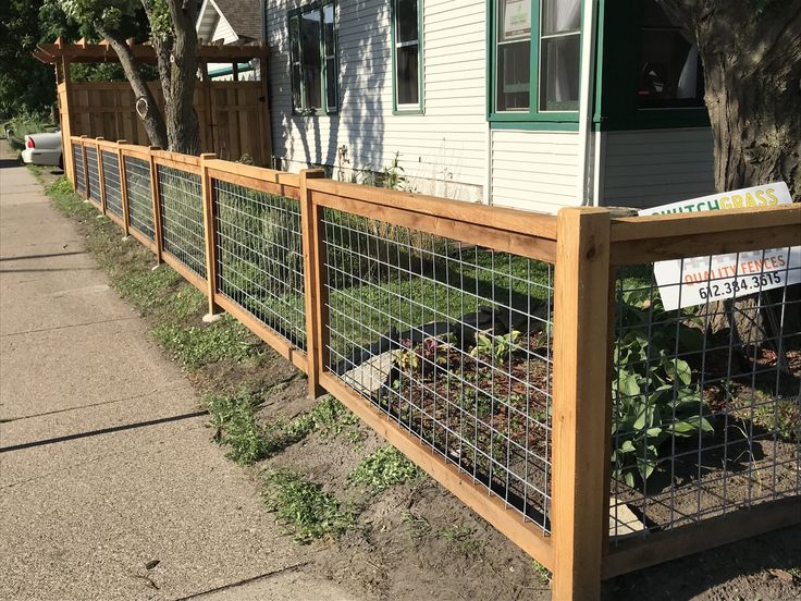 a wooden fence next to a house with a sign on it