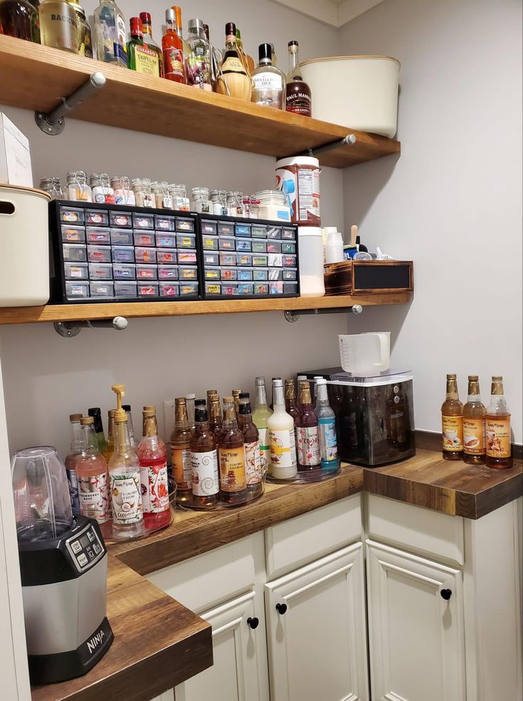 a kitchen with lots of bottles on the counter and shelves full of liquors in it