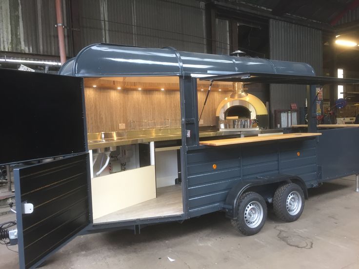 an outdoor food cart is parked in a warehouse with the door open to show what's inside