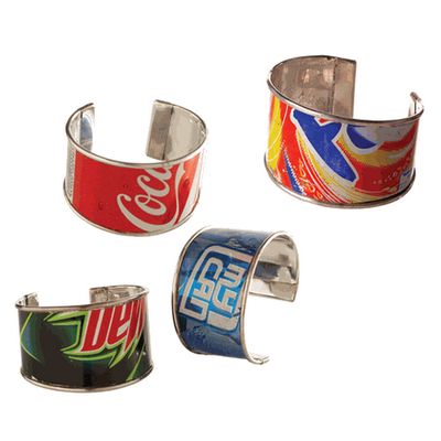 three coca cola cuff bracelets are shown in three different colors and designs, one is red, one is blue