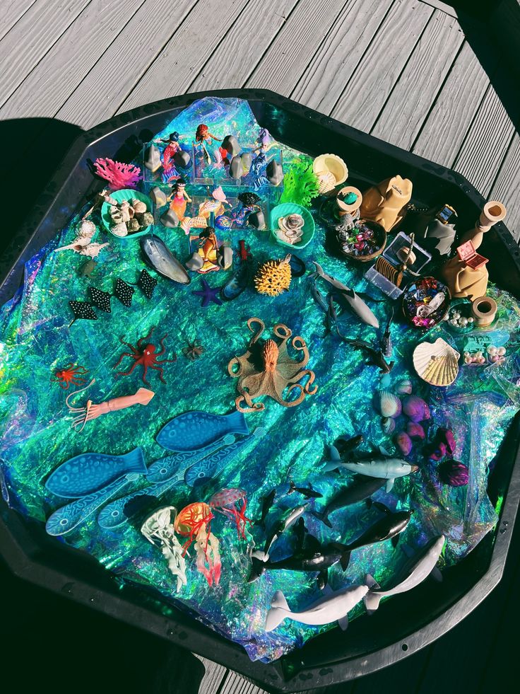 there is a tray that has many different things on top of it, including sea animals and mermaids